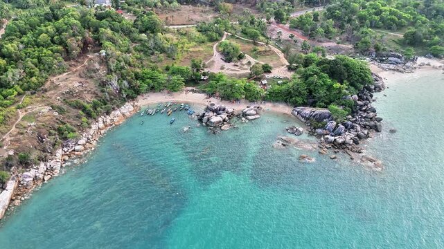Cinematic Aerial View of Turun Aban Beach Bangka Featuring Turquoise Bay, Granite Boulders, Tropical Forest and Peaceful Coastal Paradise Escape
