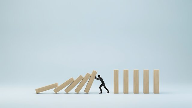 A person stops a domino effect by pushing a block, preventing a chain reaction.