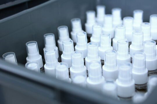 Cosmetics production. Plastic bottles without labels. A large number of vials are in the drawer. Finished products