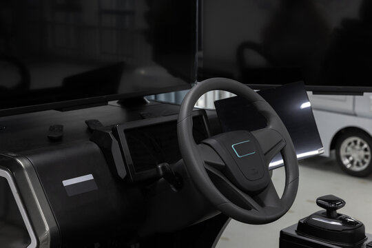 Modern vehicle simulator system featuring a close-up of a steering wheel, digital dashboard and touchscreen displays with a joystick control, conveying advanced automotive and education technology