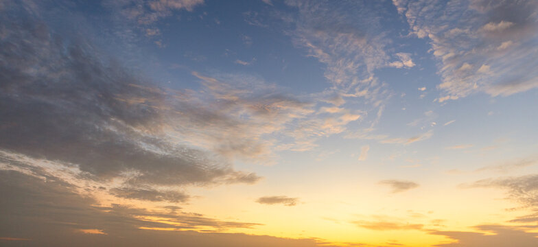 Dramatic golden hour sky with soft clouds at sunset,A beautiful and serene view of a golden hour sky, featuring soft, wispy clouds illuminated by the warm, gentle light of the setting sun, creating.