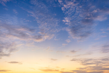 Fototapeta premium Dramatic golden hour sky with soft clouds at sunset,A beautiful and serene view of a golden hour sky, featuring soft, wispy clouds illuminated by the warm, gentle light of the setting sun, creating.