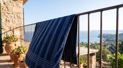 Fototapeta premium Wet towel hanging casually on villa balcony railing with blurred ocean view