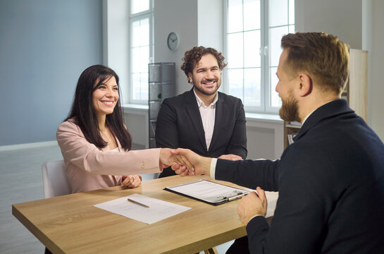 Recruiter and candidate handshake at hiring interview. Smiling managers confirm agreement and success after the meeting, welcoming a new team member to HR. Hiring win and deal concept.