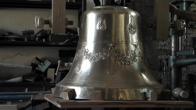 Polished Bronze Church Bell Suspended On Hoist Inside Traditional Foundry - 4K