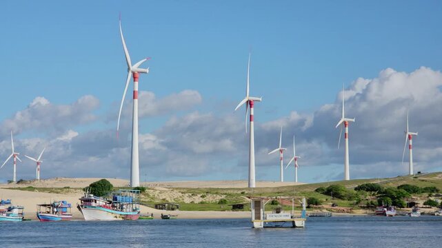 Traditional Fishing Boats on Munda&uacute; River with Massive Wind Turbines on the Dunes