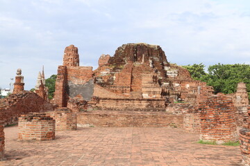 Obraz premium Ancient Ruins of Ayutthaya: Majestic brick ruins stand as a testament to a bygone era, showcasing the intricate architecture and historical grandeur of Thailand's ancient capital.