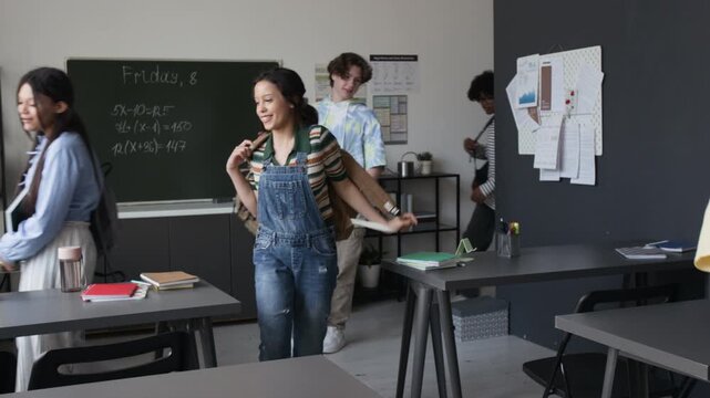 Multiethnic teenagers entering modern classroom and taking seats before lesson starts. Clip for high school education and back to school marketing campaigns