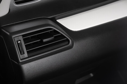 Car air vent close up on a modern vehicle dashboard featuring an interior air conditioning vent and climate control system. Detailed automobile interior highlighting ventilation, cooling, comfort.