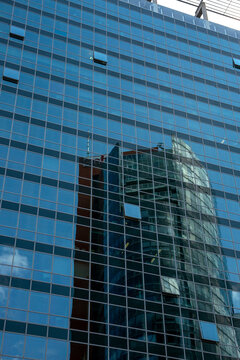 The facade of a modern multi-storey building with reflections in the windows