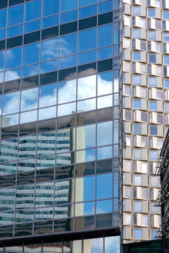 The facade of a modern multi-storey building with reflections in the windows