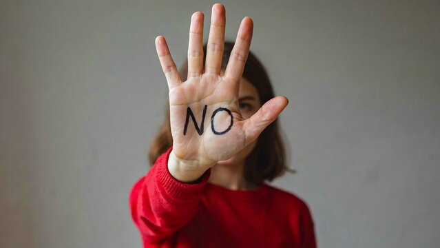 Woman showing stop gesture with no written on hand against abuse concept