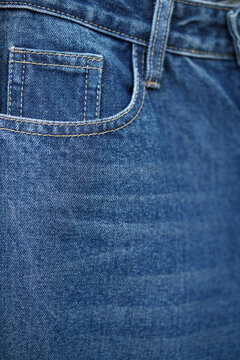 Front pocket and small pocket blue jeans pants with seam of fashion design. close up, macro. concept business, shopping, sale. Design detail, button and seams, copy space