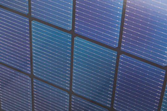 Close up of bifacial solar panel cells with blue grid texture and black frame pattern