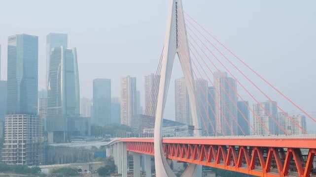 Modern cable stayed bridge crossing river with contemporary skyscrapers in Chongqing city, China. Urban development, transportation infrastructure, business districts, modern architecture