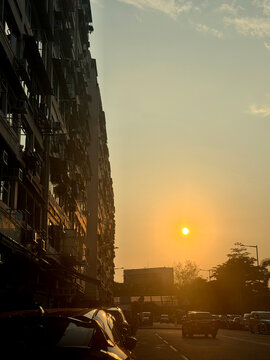 Golden hour sunset over a busy city street with apartment buildings