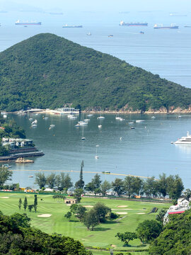 Scenic coastal landscape with a golf course and sailboats in a bay