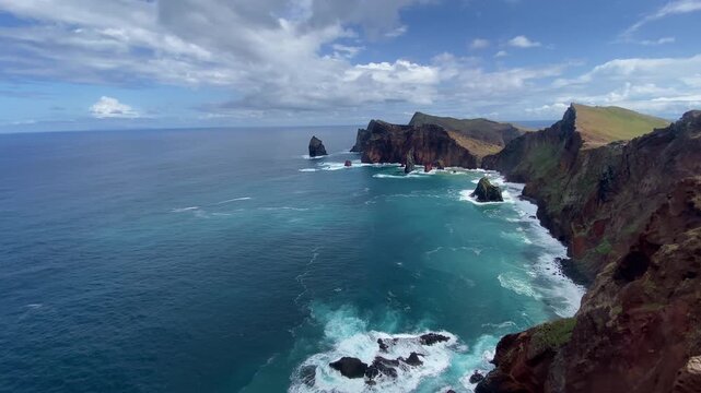 Aerial view of rugged cliffs and turquoise ocean at Madeira Ponta de S&atilde;o Louren&ccedil;o, with sea stacks and breaking surf.