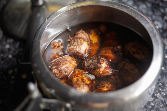 Boiled taro root cooking in a stainless steel pot