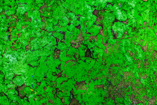 Rusty metal surface painted with cracked peeling green paint, aged industrial material weathered texture background concept