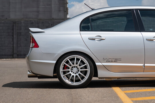 Silver Honda Civic Si side profile view, performance sports sedan rear wheel and body detail