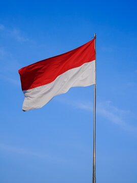 The Indonesian flag waving isolated on blue sky background