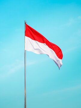 The Indonesian flag waving isolated on blue sky background