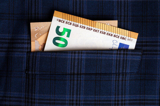 Fifty euro banknote peeking out of a blue plaid shirt pocket, symbolizing savings, finance, and personal wealth management.