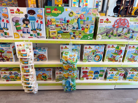 Colorful toy store shelf filled with lego duplo boxes and hanging packs for young children