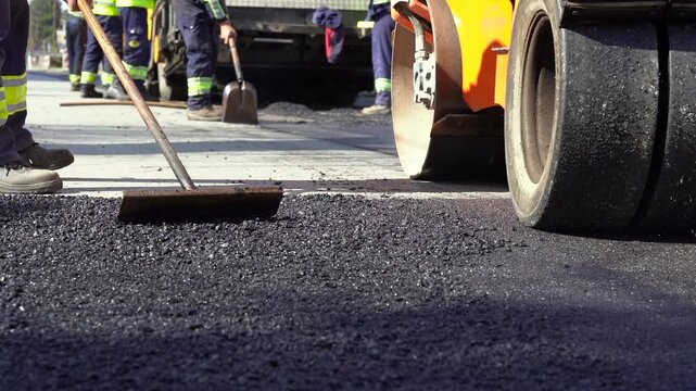 City Street Reconstruction with Combination Roller and Workers. This industrial concept video visualizes urban infrastructure development, civil engineering, and municipal public works. 