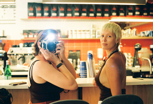 Two Women in a Cafe Taking Pictures During the Day