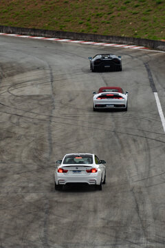 Lamborghini Aventador LP 780-4 Ultimae Roadster, Porsche 911 (992) Cabriolet, and BMW M4 (F82) driving in formation on a racetrack
