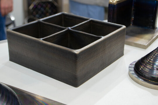 Metal four-compartment organizer container manufactured using industrial 3D metal printing. Additive manufacturing. Model printed on 3D printer. Metal alloy. Object printed on 3D printer from metal.