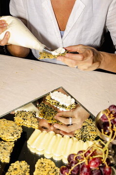 Piping whipped butter on crackers for elegant home dinner party
