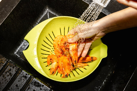 Fresh prawns rinsed in colander for catered seafood dinner