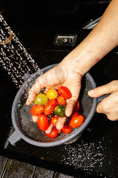 Hands rinsing colorful tomatoes for fresh healthy dinner prep