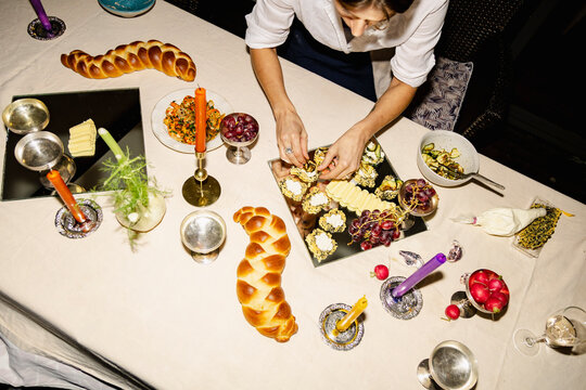 Overhead dinner table setup with challah bread and plated appetizers