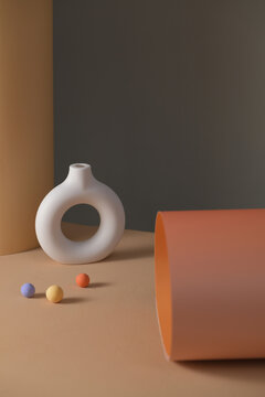 Minimalist white ceramic vase with a circular design and balls