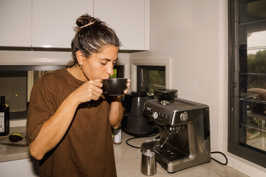 UGC Housemate drinking coffee in kitchen during real life morning
