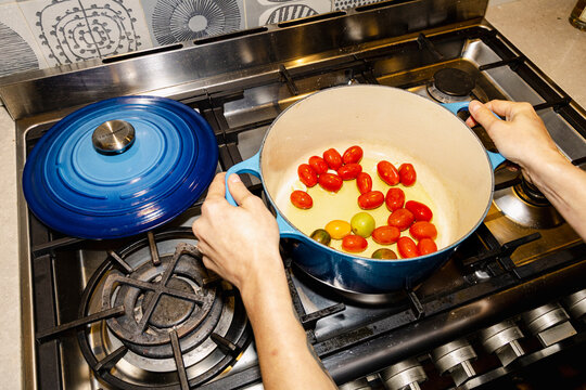 Cooking cherry tomatoes in pot for homemade dinner sauce