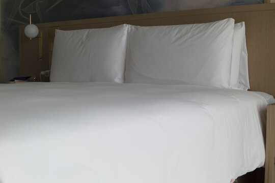White Bed in a Hotel Room With Plain Decor and Simple Design