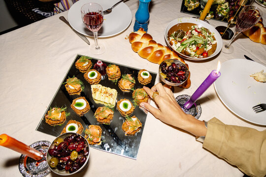 Hand taking salmon appetizer from shared dinner party platter