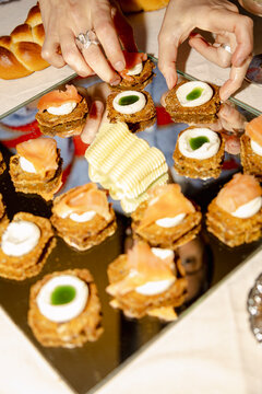 Hands adding toppings to appetizers for catered dinner party