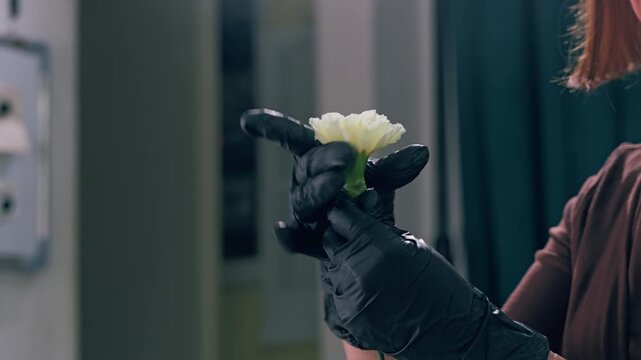 Young florist making bouquet of roses and dried flowers at workplace. Floral artist working in flower shop studio. Floristry showing masterclass on creating flower arrangement. Small woman business.