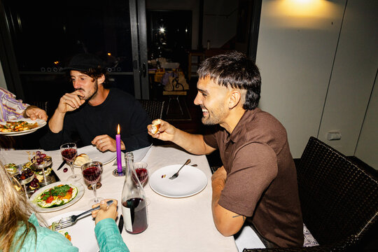 Friends eating appetizers at candlelit outdoor dinner party