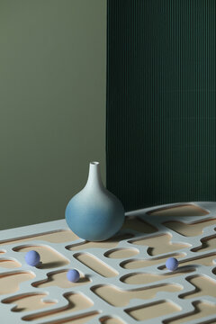 Minimalist still life featuring a blue vase and geometric shapes