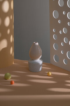 Minimalist still life composition with modern vase and colorful balls