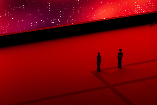 A man and woman stands in front of a large digital screen