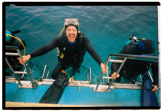 Scuba diver climbing onto dive boat in the Kerama Islands
