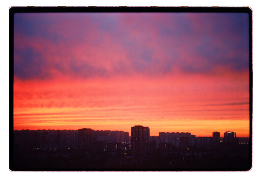 A city skyline swallowed by a burning sunset sky